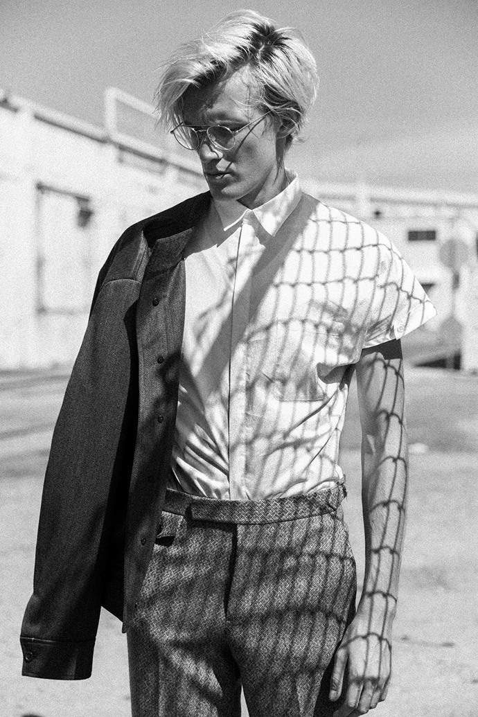 Helmut Lang white shirt, Thom Browne glasses, Brooks Brothers grey wool trousers, Brooks Brothers grey wool jacket, Brunello Cucinelli brogues