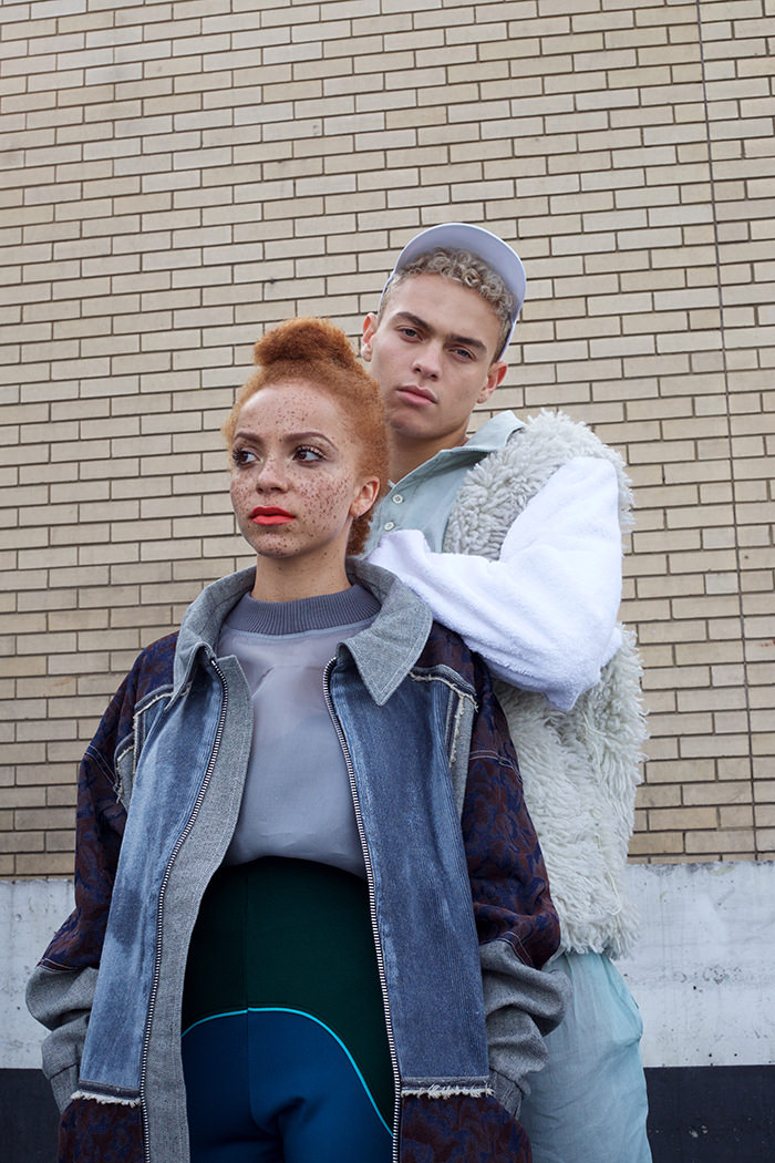 Coral wears: Top by Hayley Young, Coat by Sarah Kate Holmes & Highwaisted trousers by Keala Seitz Boots., Vintage Clarks from Rokit Joel wears: Jumper by Sarah Kate Holmes & Joggers by Hayley Young, Hat by VFILES SPORT, Trainers - Axel Arigato