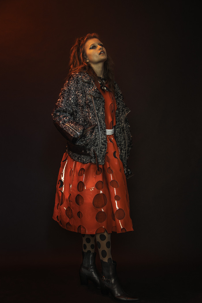  vinyl dress with cut outs and polka dot bow blouse by Comme Des Garcons, tweed and vinyl oversized motorcycle jacket Junya Watanabe, studded belt Tripp NYC, motorcycle bootie Miu Miu, tights by Hue 