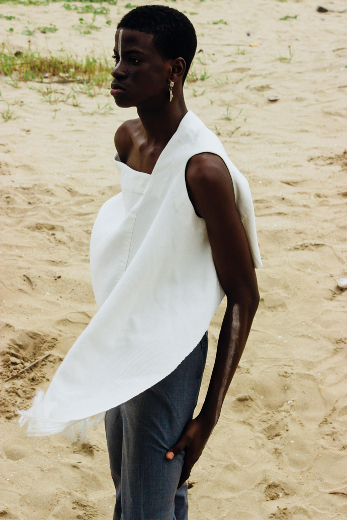 White slanted Sleevless tunic : Nkwo Grey trousers : Stylist Wardrobe